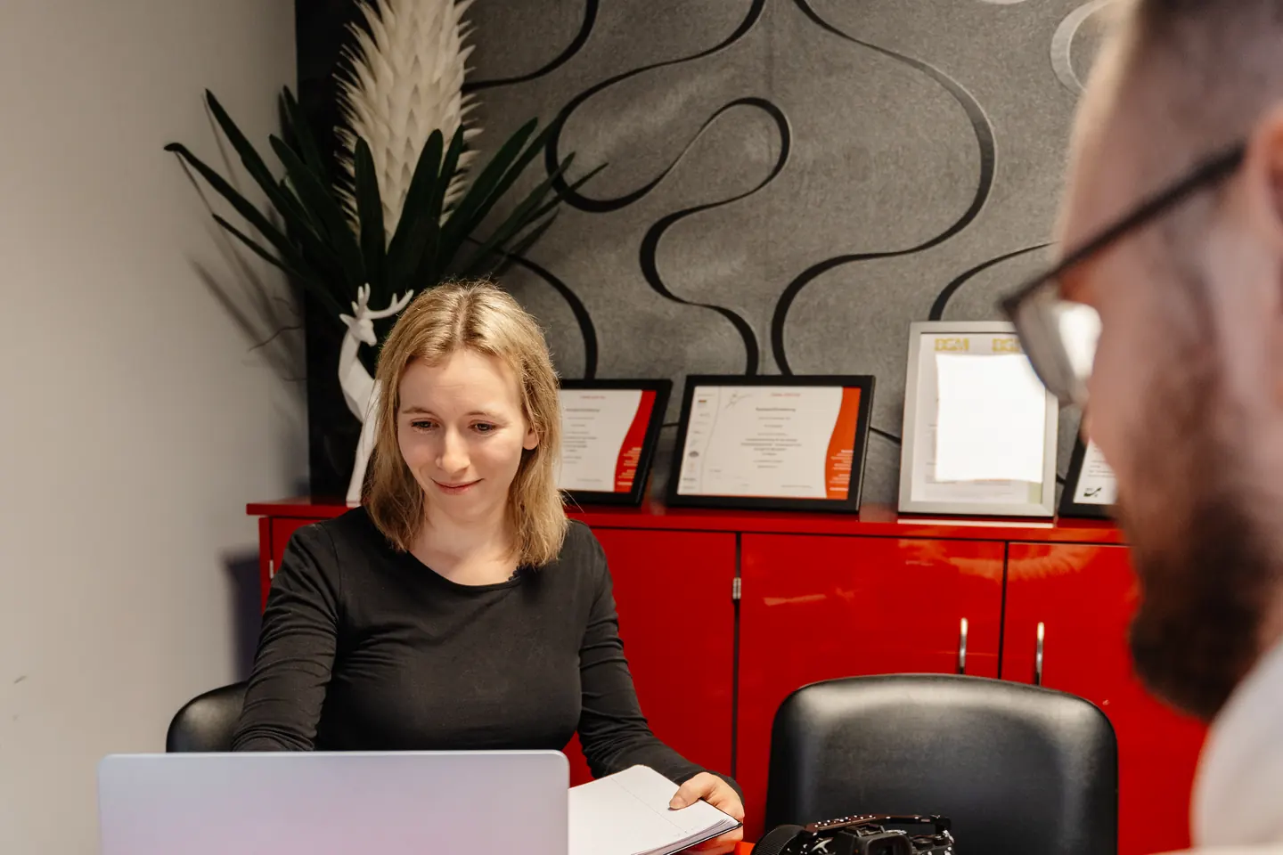 Anne bespricht mit einem Kunden die Content-Planung am Laptop
