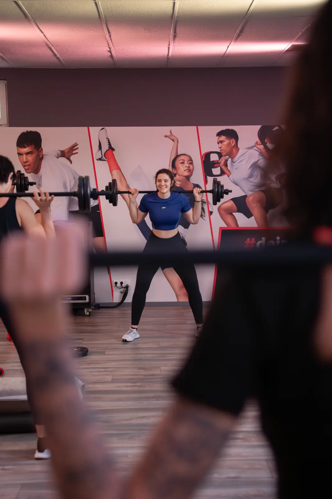 Sportlerin beim Langhantel-Training im Gruppenkurs