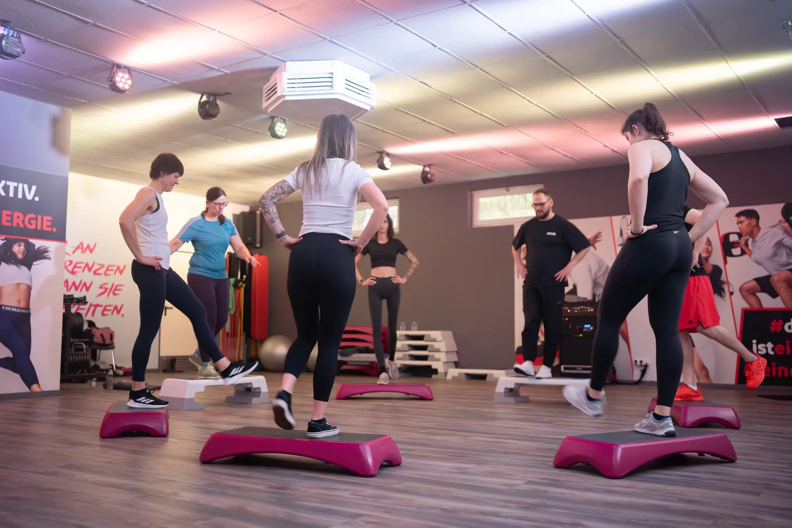 Fitnesskurs mit Stepboards und motivierter Gruppe