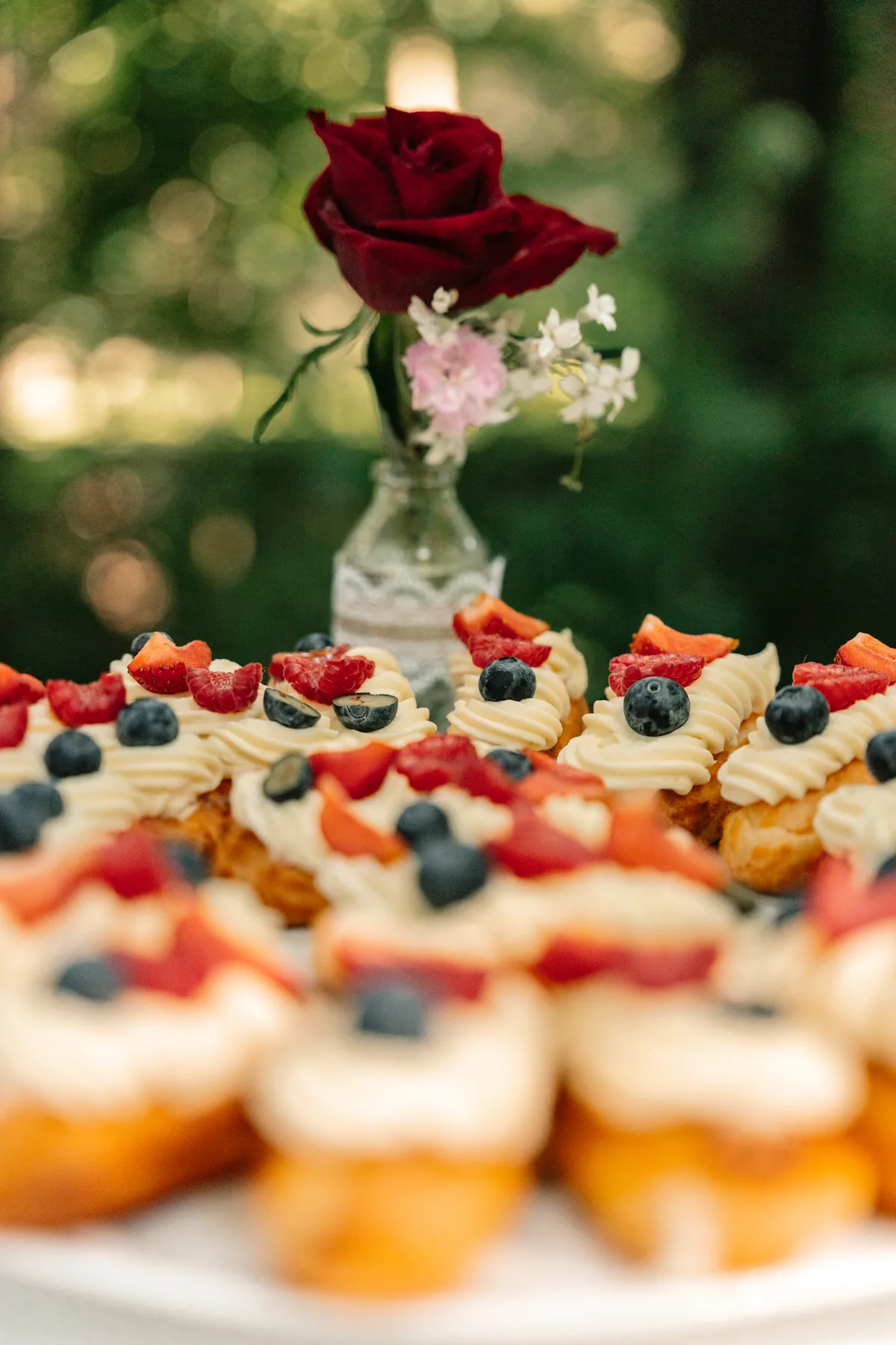 Feines Gebäck mit frischen Beeren und floraler Dekoration