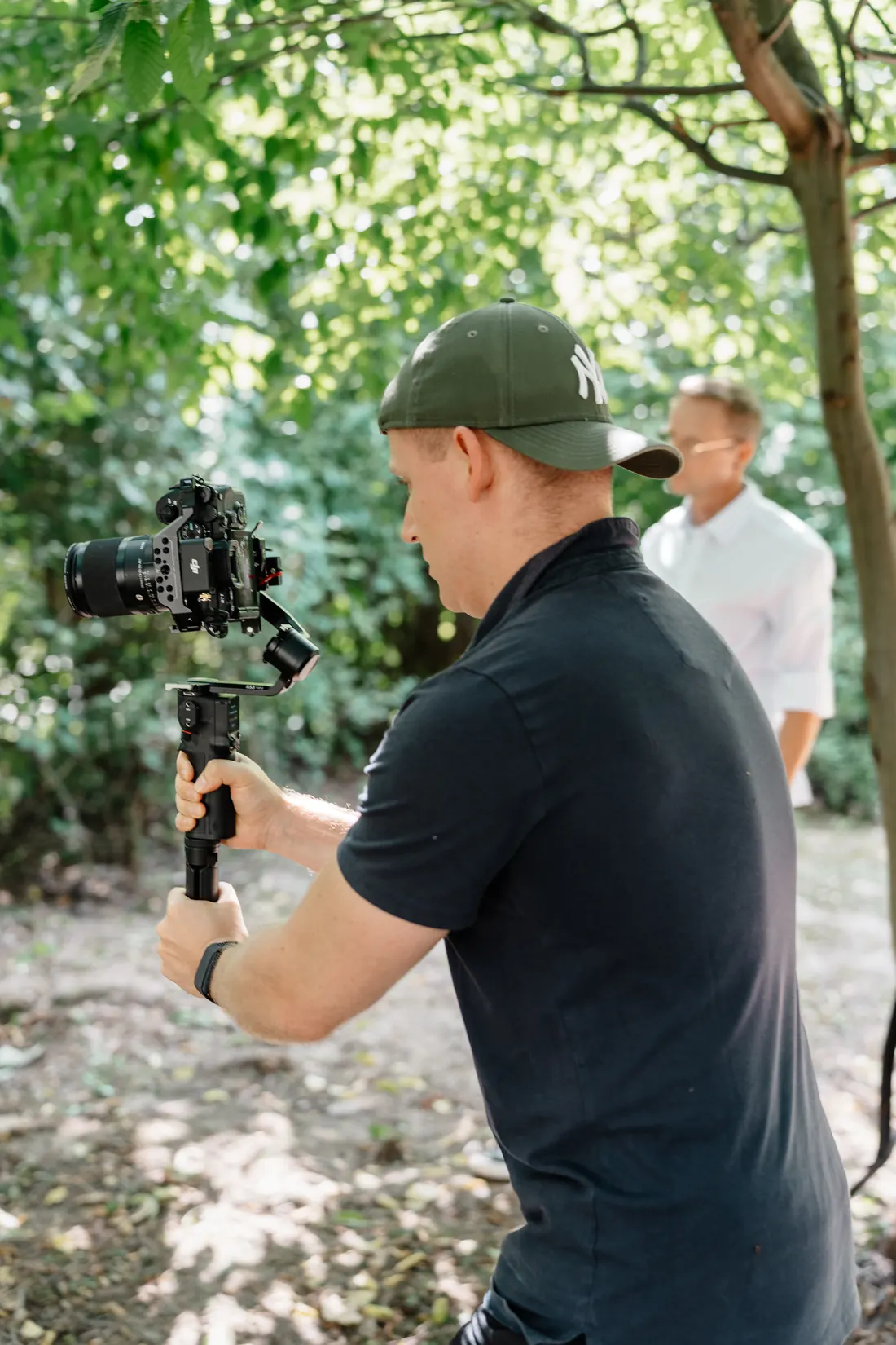 Toni führt eine Kamera auf einem Gimbal bei einer Produktion im Freien