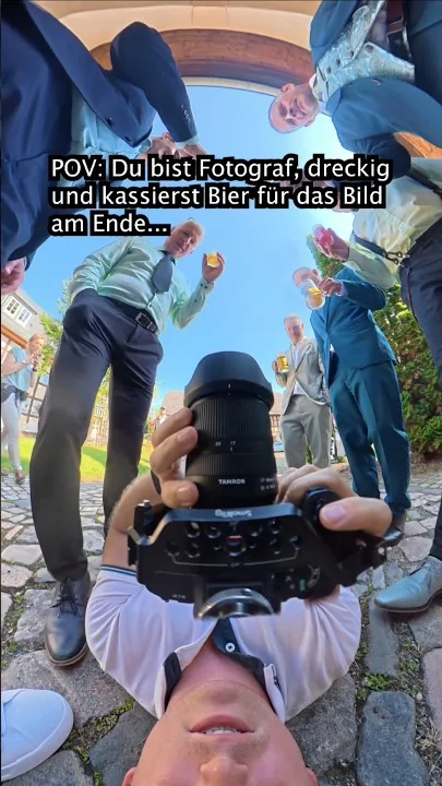 Fotograf am Boden unter Hochzeitsgästen