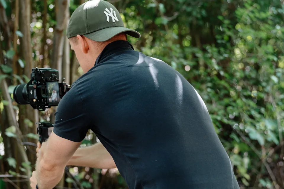 Toni filmt mit einer Kamera auf einem Gimbal im Garten