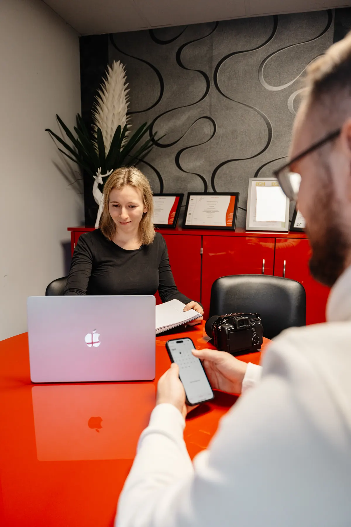 Anne spricht am Laptop mit einem Gesprächspartner am Tisch